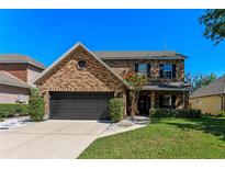 Charming two-story brick home featuring a well-manicured lawn and a two-car garage at 5388 Birchbend Loop, Oviedo, FL 32765