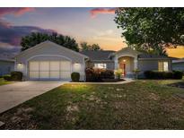 Charming single-story home with attached garage, landscaped front yard, and inviting entrance at sunset at 5962 Sw 98Th Street Rd, Ocala, FL 34476
