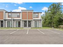 Modern townhome with sleek exterior design, gray accents, and designated parking spaces at 8802 Positivity Dr, Kissimmee, FL 34747