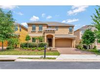 Charming two-story home with a well-maintained lawn, beautiful shrubbery and attached two car garage at 2311 Victoria Dr, Davenport, FL 33837