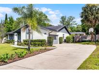 Charming single-story home featuring manicured landscaping, a spacious driveway, and a gray and white color scheme at 261 West Citrus St, Altamonte Springs, FL 32714
