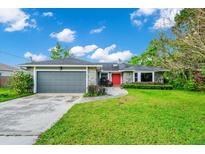 Charming home with stone accents, grey garage door, vibrant red door, and a lush green lawn at 275 W 3Rd St, Chuluota, FL 32766