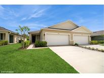 Inviting home featuring a well-maintained lawn, a two-car garage, and attractive landscaping at 2936 Sunridge Loop, St Cloud, FL 34771