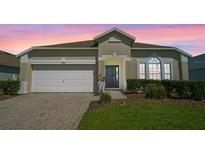 Charming single-story home featuring a well-manicured lawn, brick driveway, and a two-car garage at 838 Kildrummy Dr, Davenport, FL 33896