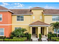 Beautiful two story exterior of townhome featuring tiled roof and lush landscaping at 8971 California Palm Rd, Kissimmee, FL 34747