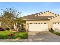 Charming single-story home with a well-maintained lawn and a two-car garage on a sunny day at 122 Lower Lake Ct, Debary, FL 32713