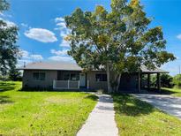Charming single-story home with a well-manicured lawn, inviting front porch, and covered parking in a quiet neighborhood at 1312 Simmons Rd, Kissimmee, FL 34744