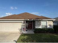 Charming single-story home featuring a well-maintained lawn and a welcoming two-car garage at 1381 Woodlark Dr, Haines City, FL 33844