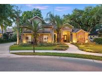 Charming two-story home with a manicured lawn, lush landscaping, and elegant stone accents at 1544 Hunters Mill Pl, Oviedo, FL 32765