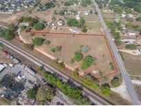 Expansive property featuring a mix of open space, mature trees, and residential structures, conveniently situated near railways at 2300 Olsen Rd, Haines City, FL 33844
