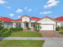 Charming single-story home boasts a red tile roof, manicured lawn and inviting curb appeal at 2335 Symphony Cir, St Cloud, FL 34771