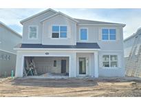 New two-story home featuring an attached two-car garage and white accents against the gray siding at 2666 Great Heron Ave, St Cloud, FL 34773