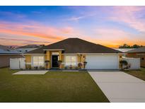 Charming single-story home featuring a well-maintained lawn, inviting entrance, and attached two-car garage at 408 Magpie Ct, Kissimmee, FL 34759
