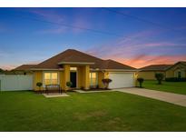 Charming single-Gathering home featuring a well-manicured lawn and attached two-car garage with twilight sky backdrop at 408 Magpie Ct, Kissimmee, FL 34759