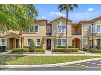 Inviting townhome with manicured landscaping, complemented by a stately palm tree and arched entryway at 458 Ellis Square Ct, Sanford, FL 32771