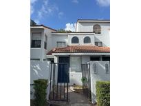 Charming townhouse exterior with black gated entrance, terracotta tile roof, and well-maintained landscaping at 4706 Sutton Ter # 111A2, Orlando, FL 32811