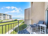 Relax on the balcony with seating and enjoy beautiful views of the ocean and the green lawn at 4821 Saxon Dr # 201B, New Smyrna Beach, FL 32169
