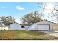 Charming white home with a well-manicured lawn, attached garage, and inviting curb appeal at 621 Ashberry Ln, Altamonte Springs, FL 32714