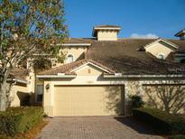 Charming villa with a two-car garage, red-tiled roof, and well-maintained landscaping in a sunny setting at 6240 Miramonte Dr # 102, Orlando, FL 32835