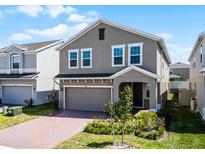 Charming two-story home with a brick driveway, attached garage, and well-maintained landscaping at 14613 Erice Ave, Clermont, FL 34714