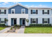 Charming two-story townhome with light blue siding, a well-kept lawn, and appealing front entryway at 301 Jetty Way, Davenport, FL 33897