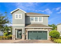 Two-story home with a stone-accented facade, well-manicured landscaping, and a two-car garage for curb appeal at 321 Falls Dr, Kissimmee, FL 34747
