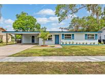 Charming single-story home featuring a well-manicured lawn and blue accent details at 4415 Gilpin Way, Orlando, FL 32812