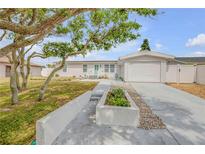 Charming single-story home featuring a well-manicured lawn, mature tree, and attached one car garage at 4443 Doris Dr, New Smyrna Beach, FL 32169