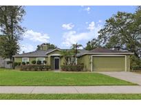 Charming one-story home featuring a well-manicured lawn, and attached two-car garage at 817 Benton Lake S Dr, Deland, FL 32724