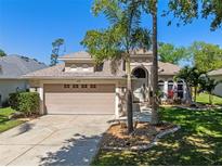 Charming single-story home with a well-manicured lawn and mature landscaping, including palm trees at 902 Wingate Trl, Port Orange, FL 32128