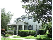 Charming two-story home features a covered porch, manicured landscaping, and classic architectural details at 14522 Old Thicket Trace, Winter Garden, FL 34787