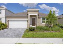 Charming single-story home with a well-manicured lawn, paver driveway, and inviting front entrance at 2030 Firethorn Loop, Haines City, FL 33844