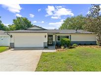Charming single-story home with a well-manicured lawn, a two-car garage and inviting front entrance at 2839 Tamarack Trl, Apopka, FL 32703