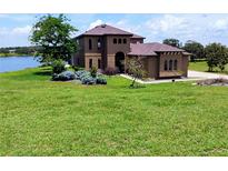 Stunning two-story home boasts a lake view, beautiful landscaping, and a well-manicured lawn at 36813 Barrington Dr, Eustis, FL 32736
