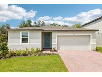 Charming single-story home featuring a blue front door, two-car garage, and landscaped front yard at 4701 Jasmine Cir, Leesburg, FL 34748