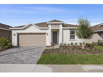 Charming single-story home featuring a two-car garage, manicured landscaping, and a welcoming entrance at 527 Silver Palm Dr, Haines City, FL 33844