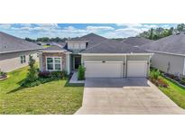 Inviting two-story home with a two-car garage, manicured lawn, and stone accents, creating curb appeal at 7563 Sw 78Th Ter, Ocala, FL 34481