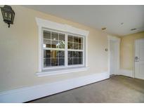 Exterior view showing a large window with white trim and stucco wall under a covered entry at 7651 Whisper Way # 104, Reunion, FL 34747