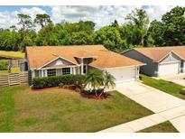 Charming single-story home with a well-manicured lawn, lovely landscaping, and a two-car garage at 11005 Cypress Leaf Dr, Orlando, FL 32825