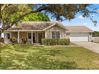 Charming single-story home with a well-manicured lawn, cozy front porch, and attached two car garage at 1563 Dess Dr, Orlando, FL 32818