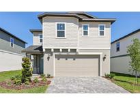 Charming two-story home with a neatly paved driveway and attached two-car garage, exuding modern curb appeal at 2236 Hen Rd, Minneola, FL 34715