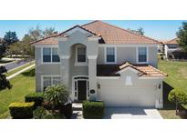 Charming two-story home with a well-manicured lawn, tile roof, and attached two-car garage at 2530 Holtrock St, Kissimmee, FL 34747