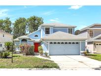 Charming two-story blue home featuring a front-facing two car garage and a vibrant red front door at 271 Morning Glory Dr, Lake Mary, FL 32746