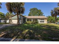 Charming single-story home featuring tropical landscaping, stone accents, and an attached two-car garage at 3220 Cardigan Ct, Orlando, FL 32812