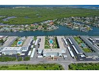 Overhead shot of a waterfront condominium complex with pools, carports, and lush surroundings on the coast at 325 N Causeway # D-206, New Smyrna Beach, FL 32169