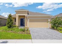 Charming single-story home features a manicured lawn, paver driveway, and inviting front entrance at 503 Silver Palm Dr, Haines City, FL 33844