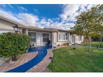 Charming single story home with a brick walkway, blue accents, and mature landscaping at 509 Eastwood Ln, Daytona Beach, FL 32118