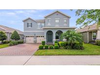 Charming two-story home with a well-manicured lawn and a three-car garage at 10133 Merrymeeting Bay Dr, Winter Garden, FL 34787