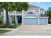 Charming two-story light blue home with well-manicured lawn and a three-car garage at 1128 Brantley Estates Dr, Altamonte Springs, FL 32714