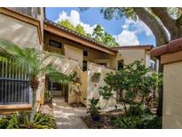 Exterior of the condo with brick and tropical landscaping leading to the front door at 1270 Saint Tropez Cir # Ge, Orlando, FL 32806